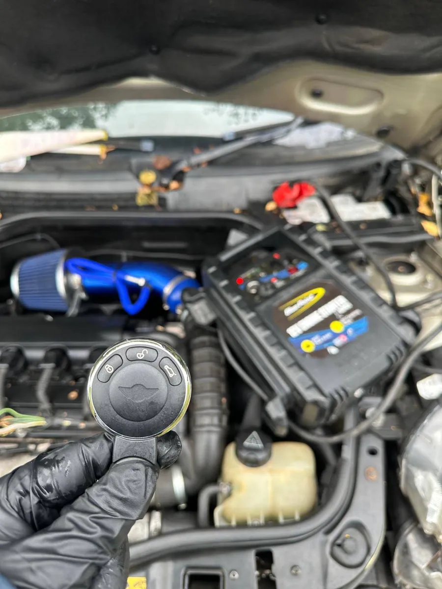MINI remote key held beside the vehicle engine bay