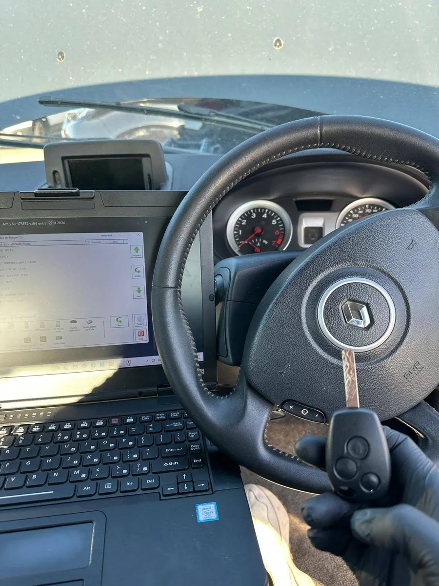 Renault key beside a laptop inside a vehicle